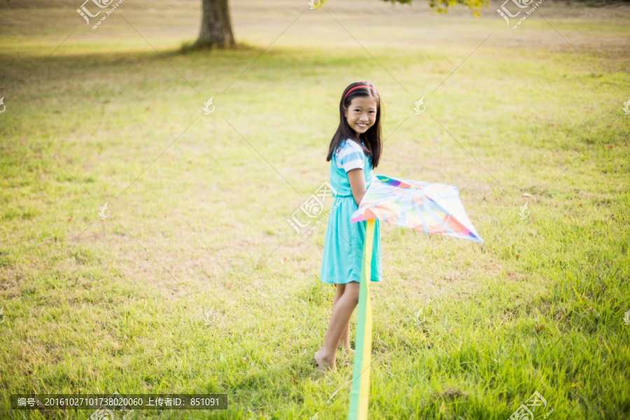 在公园里放风筝的小女孩