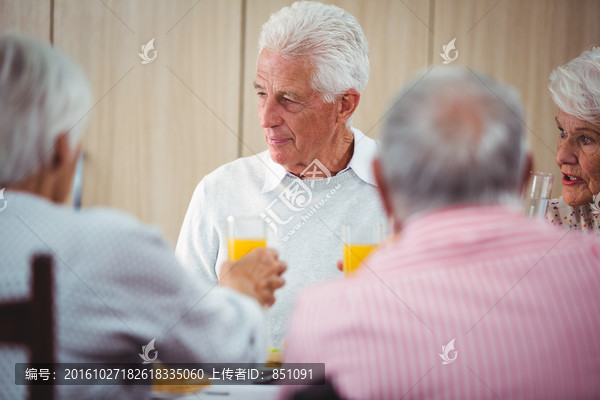 有橙汁饮料的老年人