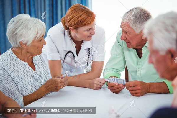 护士看着玩牌的老年人