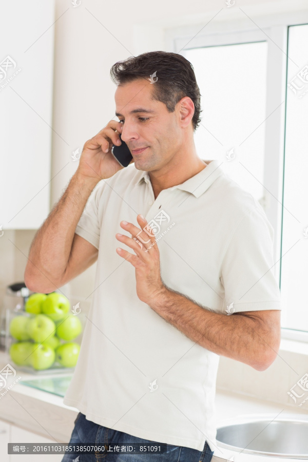 在厨房里使用手机的男人