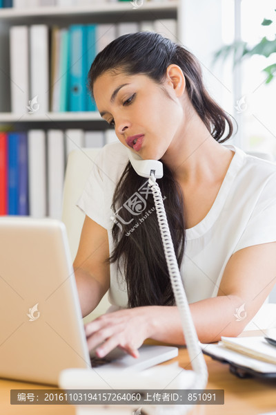 使用笔记本电脑打电话的商务女人