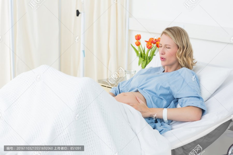 坐在病床上阵痛的孕妇