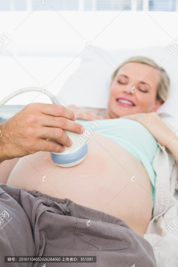 微笑的孕婦在醫(yī)院接受超聲檢查