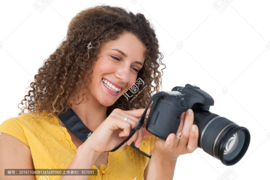 看着相机里的照片的女摄影师