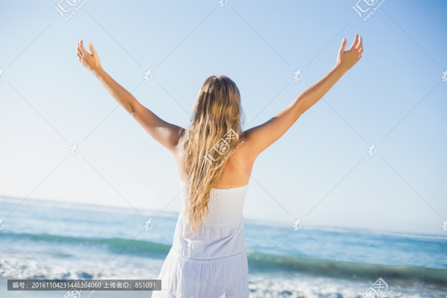 举起手臂在海边的女人