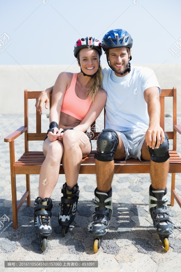 穿着溜冰鞋坐在长椅上的情侣