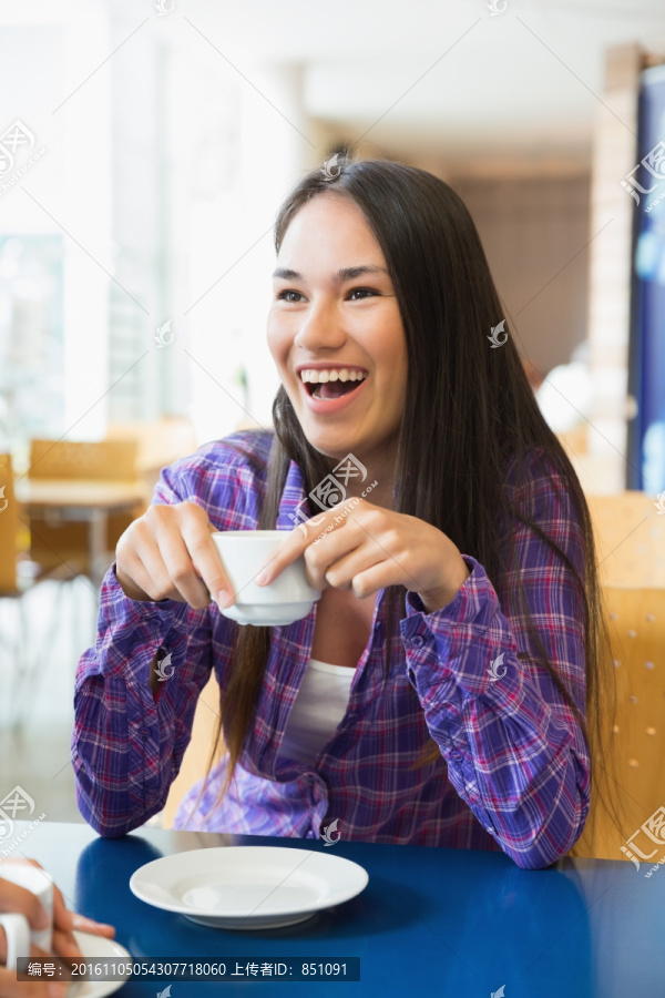 开心的女人在喝一杯咖啡