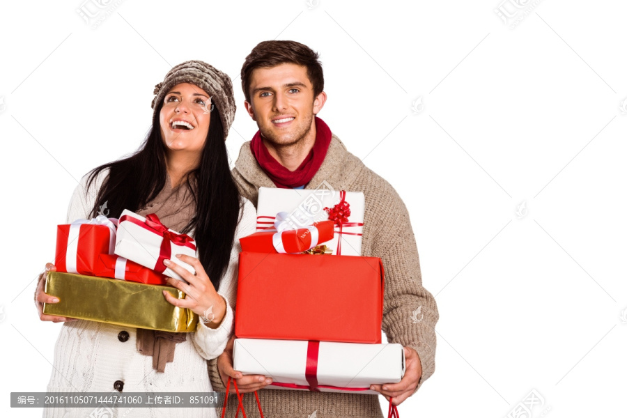 抱着一堆圣诞礼物的年轻夫妇