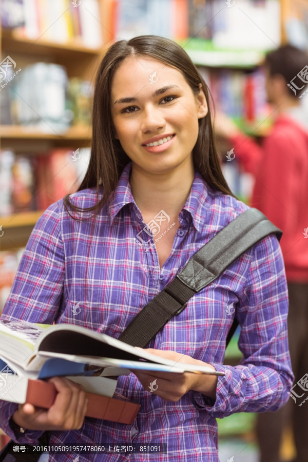 微笑的女学生在图书馆里看书