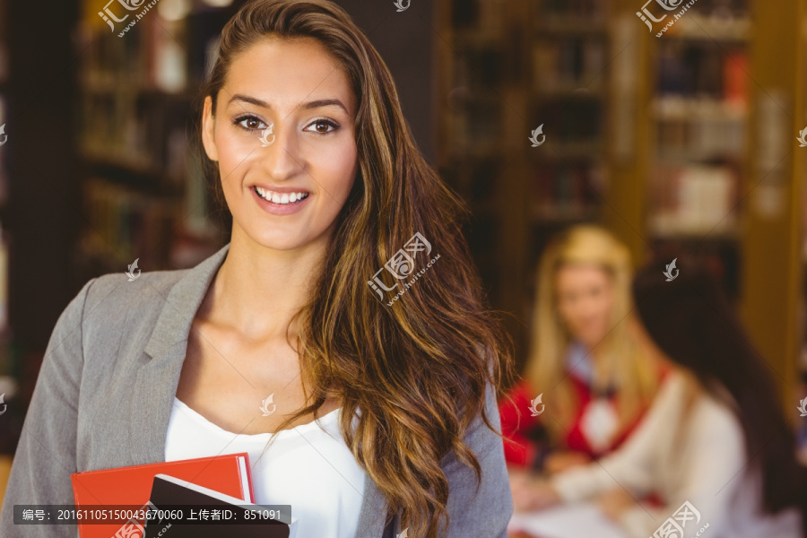 微笑的女大学生在图书馆里