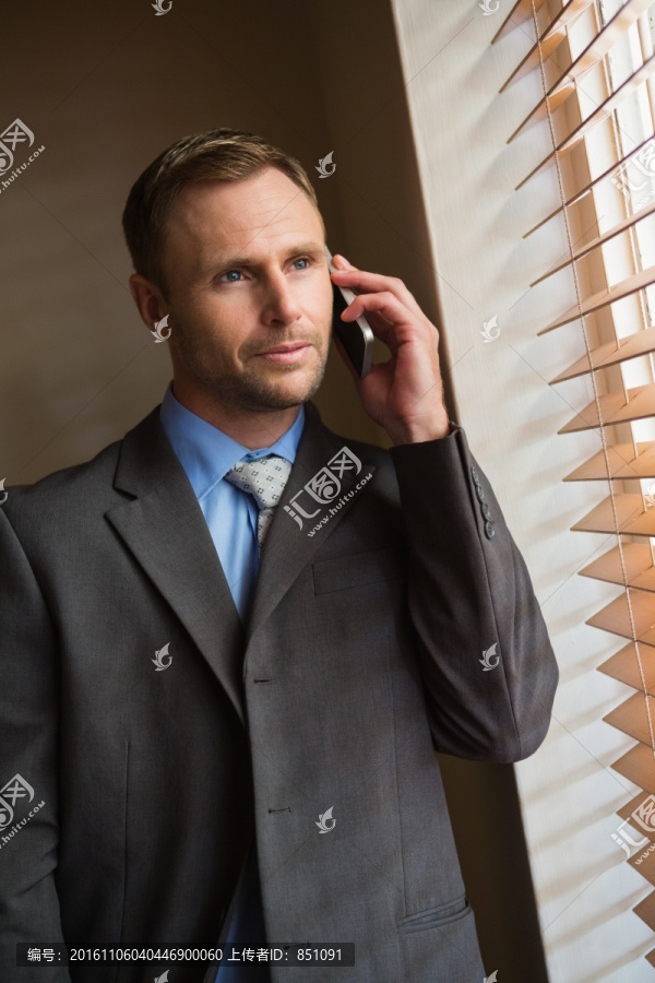 看着窗外打电话的商务男人