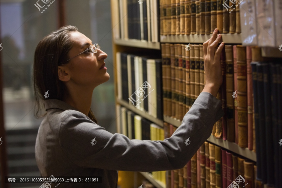 在图书馆里挑选书的女律师