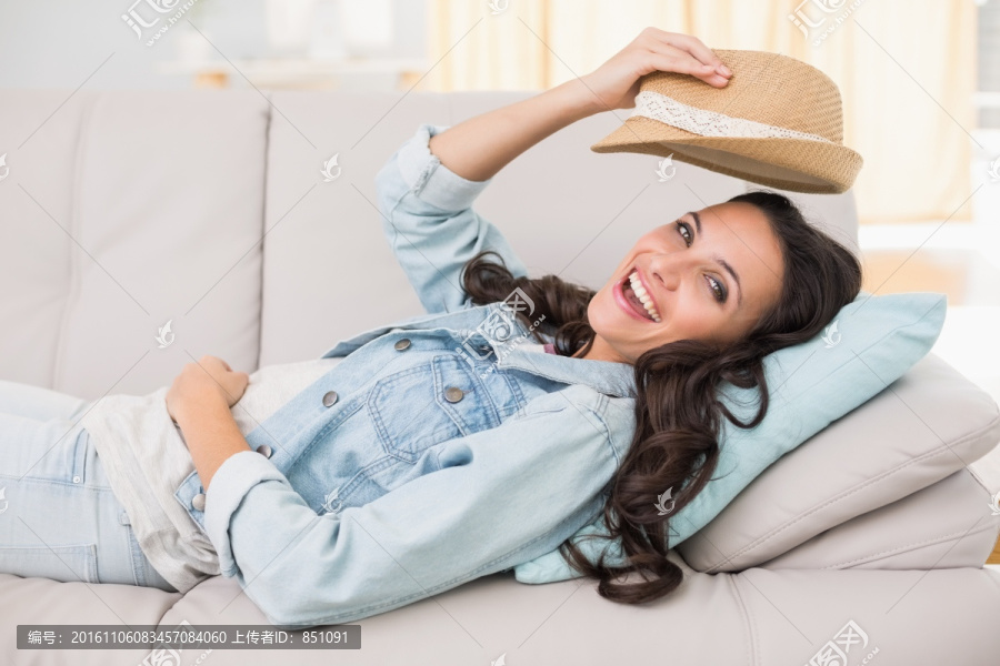 躺在沙发上拿着帽子的女人