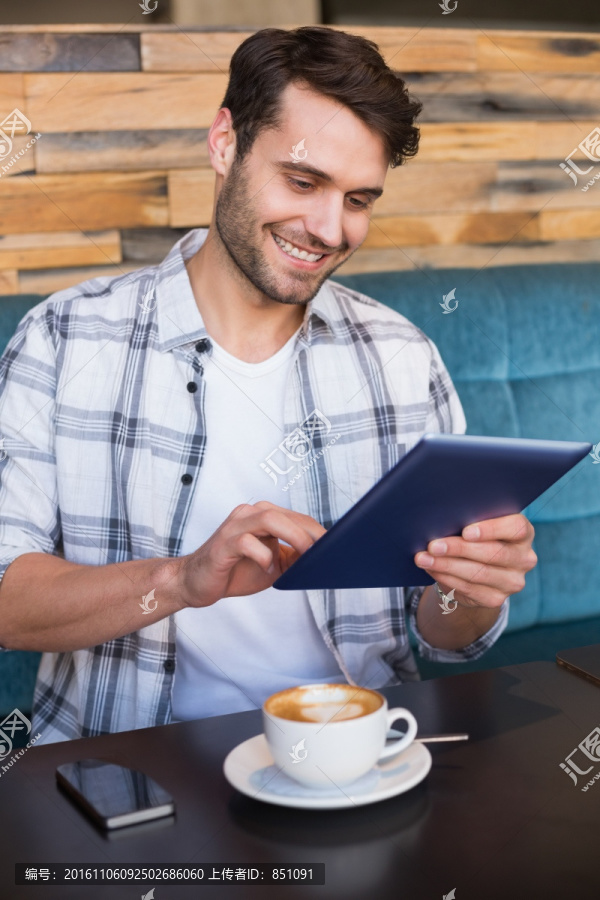 微笑着使用平板电脑的男人