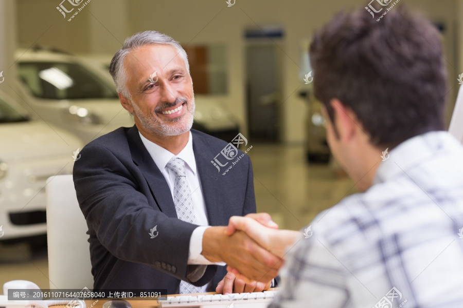 微笑着和客户握手的男人