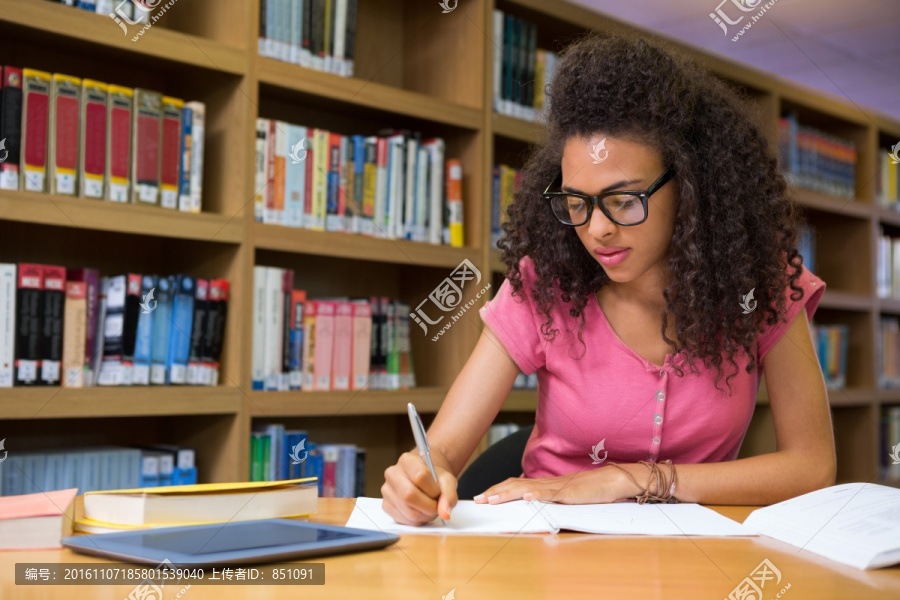 学生坐在大学的图书馆里写作