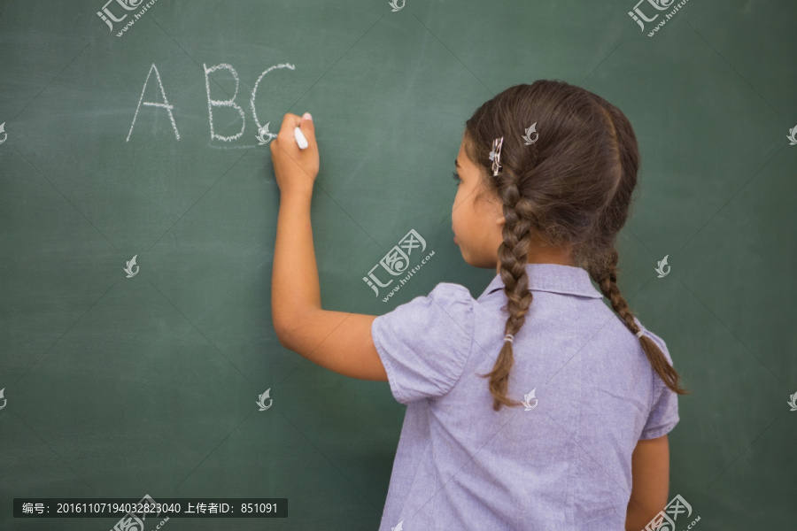 小学生在黑板上写字母