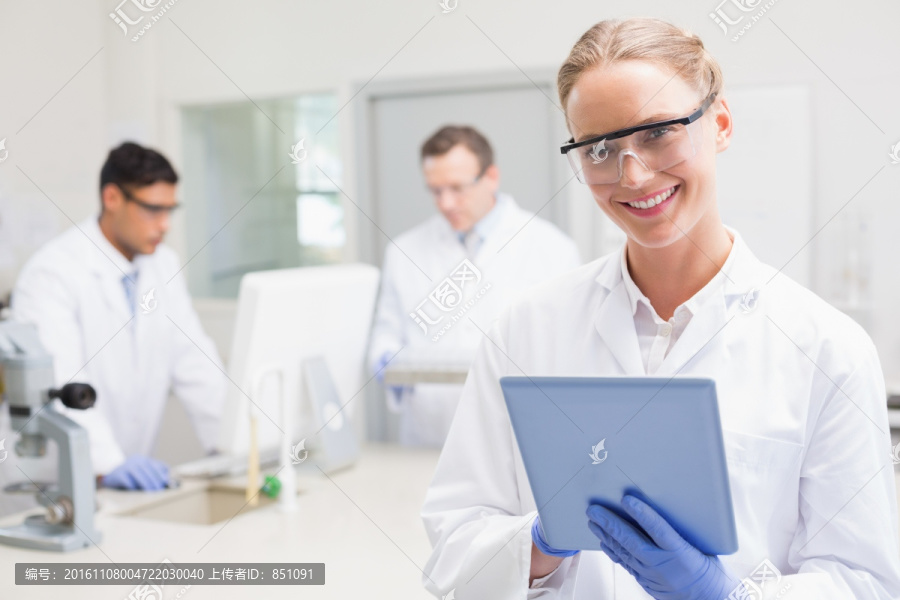 微笑的科学家使用平板电脑
