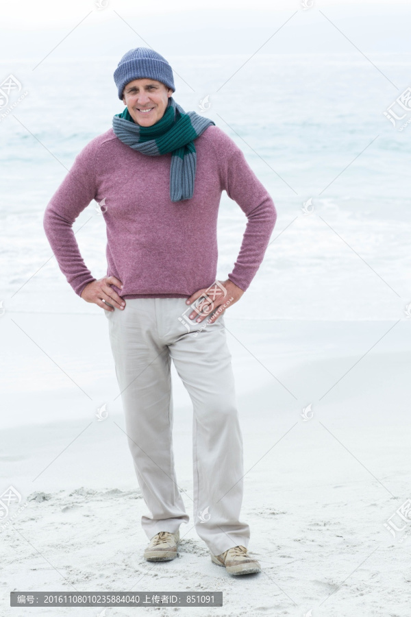 穿着暖和的衣服站在海滩上的男人