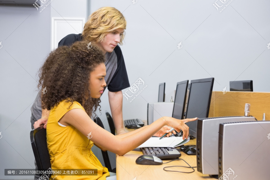 在教女同学电脑课的男学生