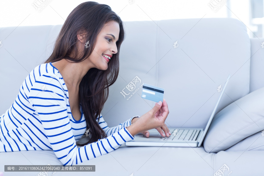 微笑着在电脑上网购的女人