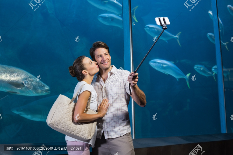 站在水族馆里自拍的男女