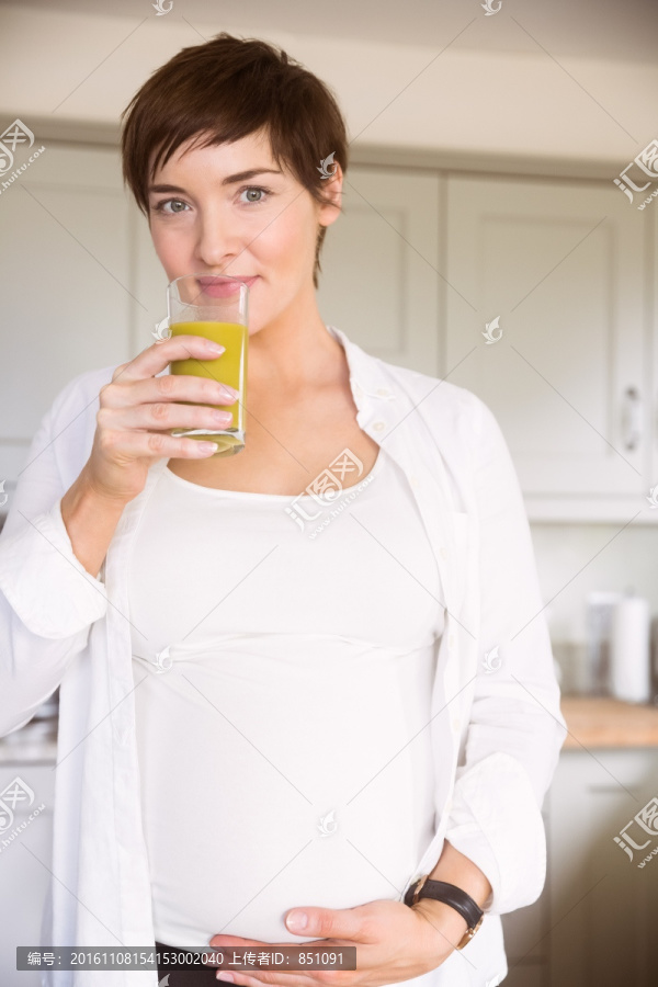 喝着橙汁的孕妇