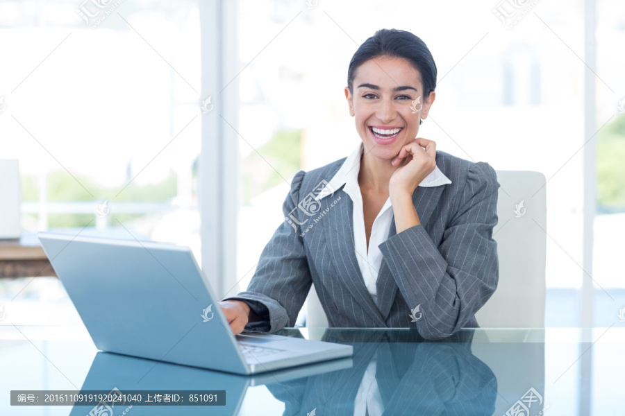 微笑的商人使用笔记本电脑