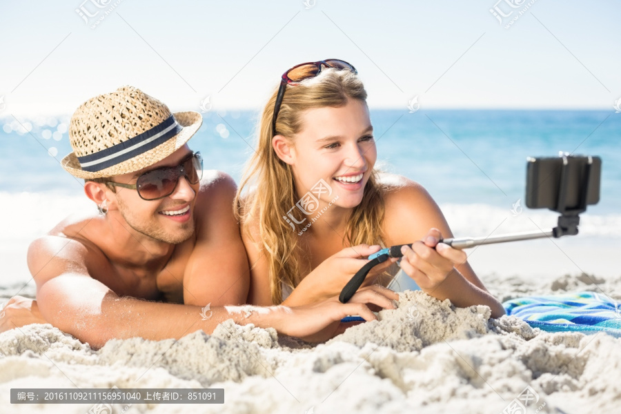 趴在沙滩上自拍的夫妇