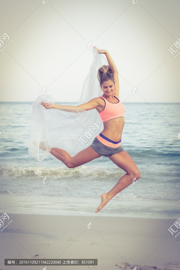 在沙滩上跳跃的女人
