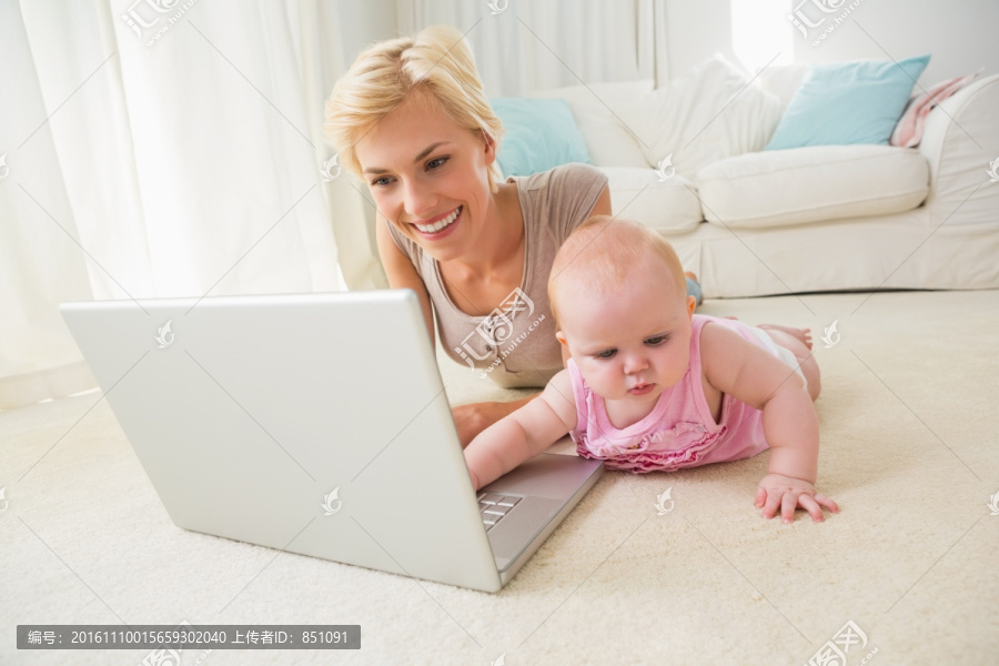 金发母亲和女儿一起用笔记本电脑