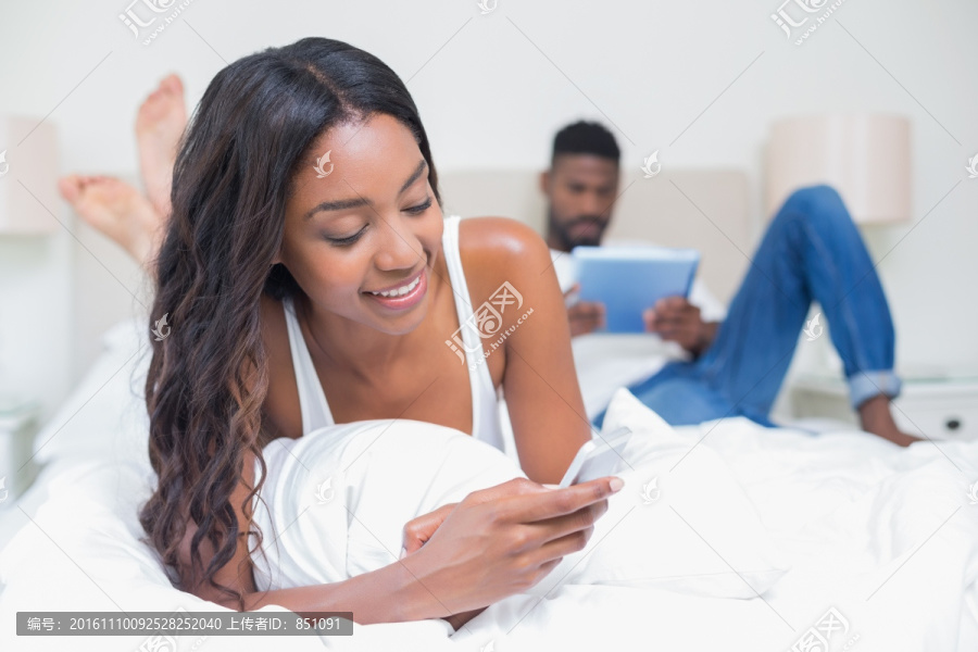 在床上使用手机的女人