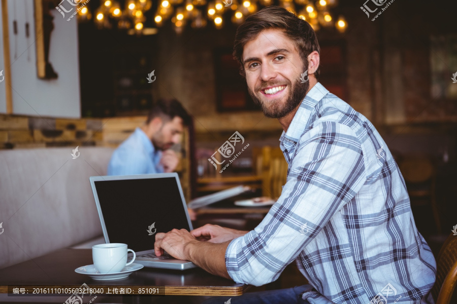 坐在咖啡馆里使用电脑的男人