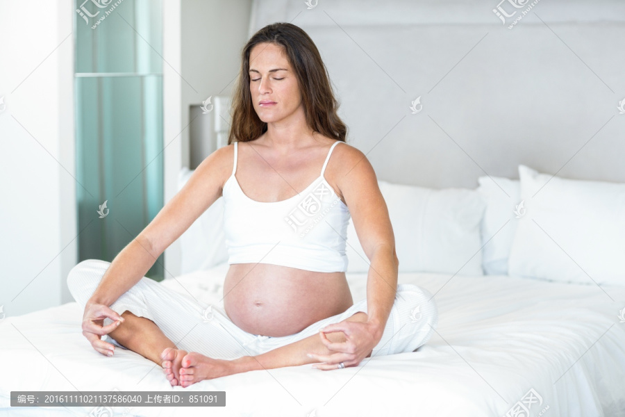 坐在床上冥想的孕妇