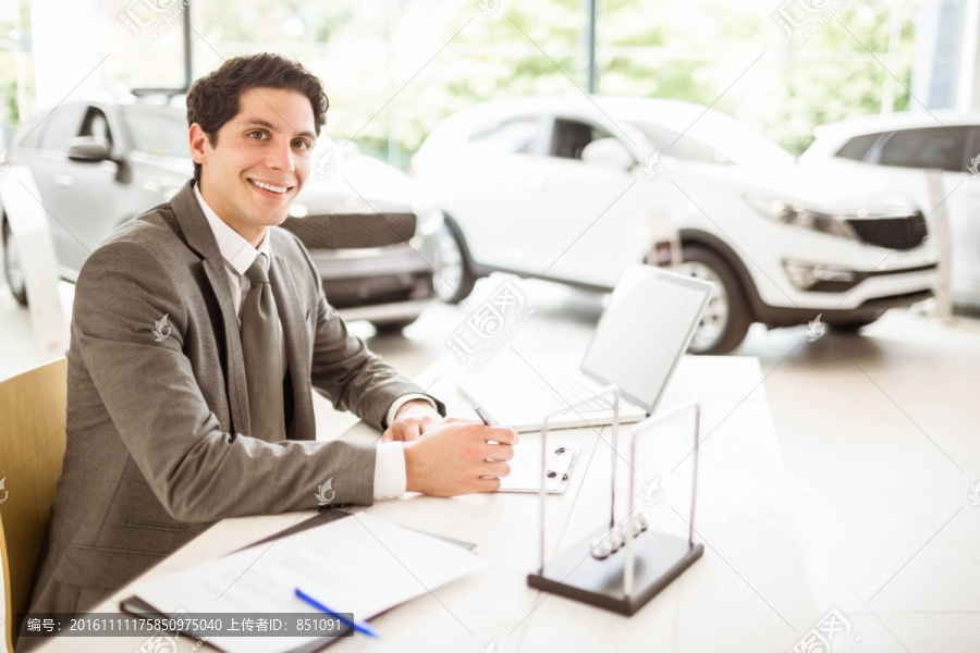 在办公桌前工作的男汽车销售员