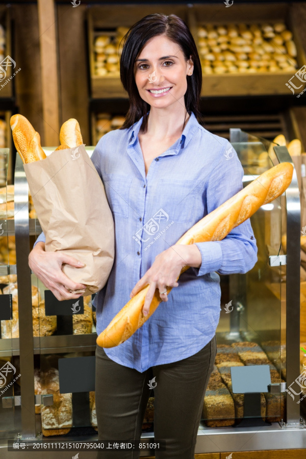 美丽的女人在超市选择她的面包