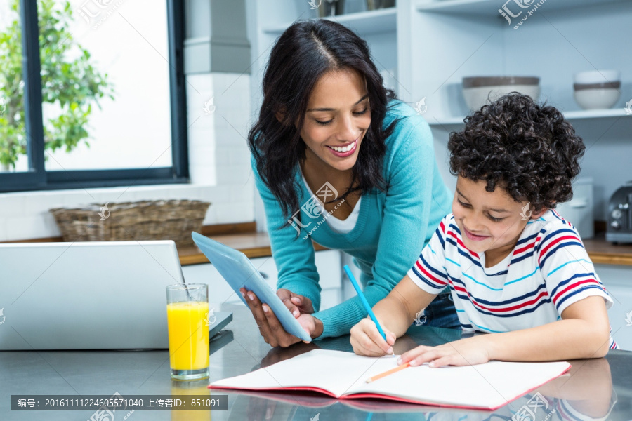 在厨房里教孩子写作业的母亲