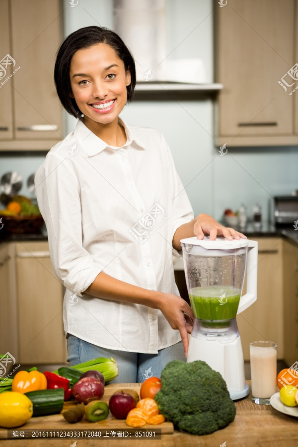 在厨房里里榨蔬菜汁的女人