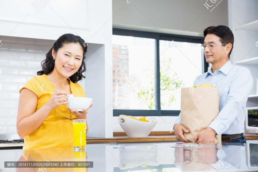 在厨房吃早餐的女人和身边的丈夫