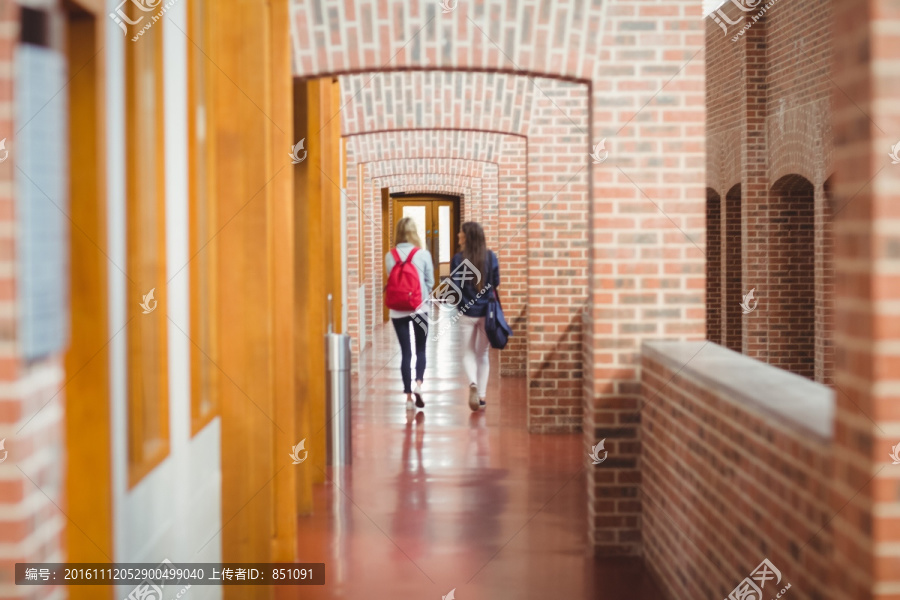 背着包的两名大学生在走廊上
