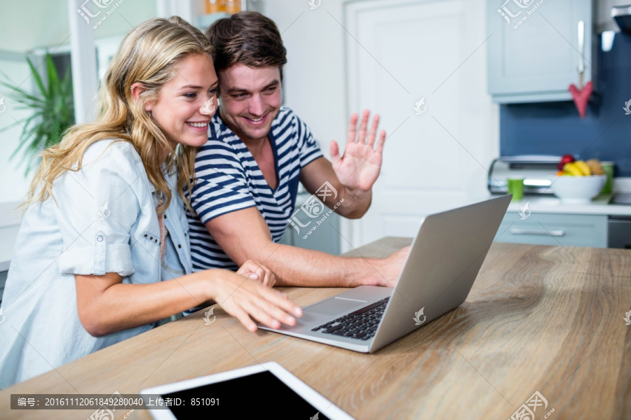 微笑着看着笔记本电脑的男女