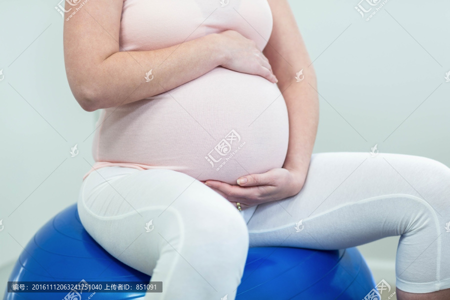 坐在健身球上的孕妇