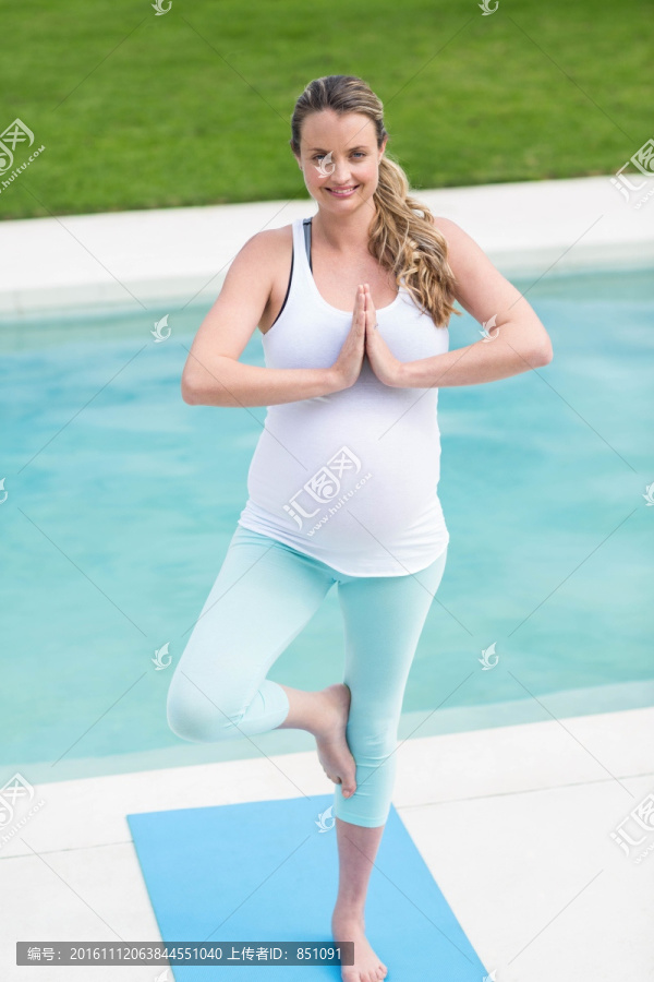 孕妇在游泳池旁边做瑜伽