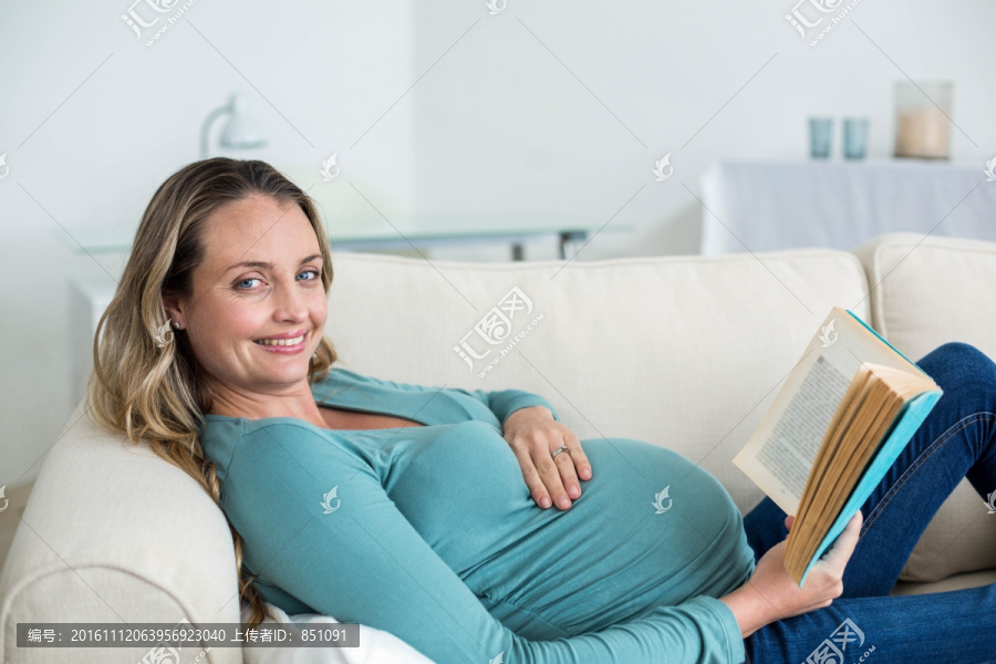躺在沙发上看书的孕妇