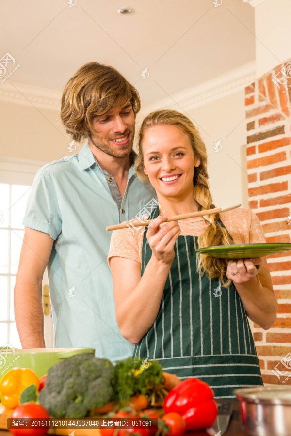 在烹饪食物的女人和身后的丈夫