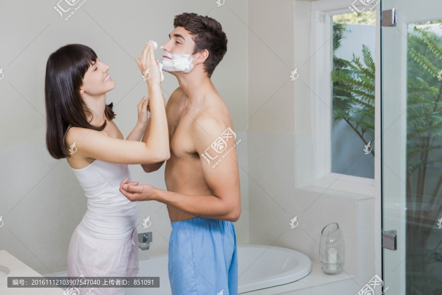 在给丈夫脸上涂剃须膏的女人