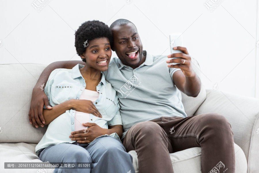 微笑着拿着手机自拍的夫妇