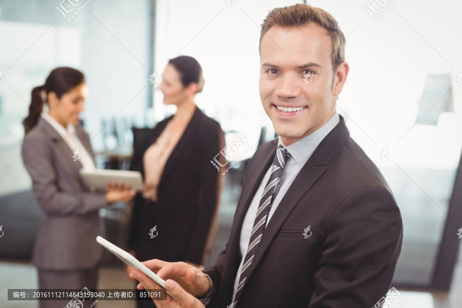 微笑着使用平板电脑的商务男人