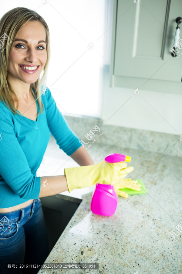 微笑得女人在清洁剂厨房台面