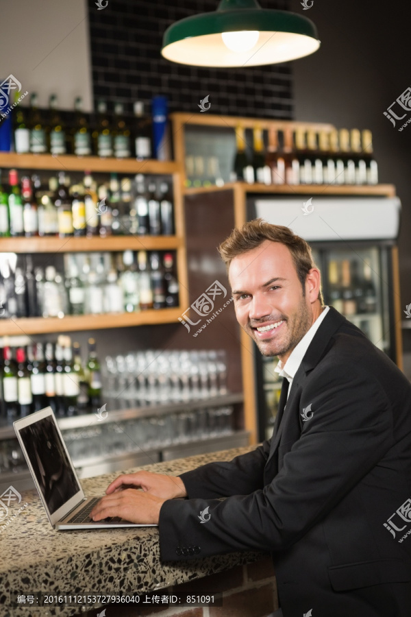 英俊男子在酒吧里使用笔记本电脑